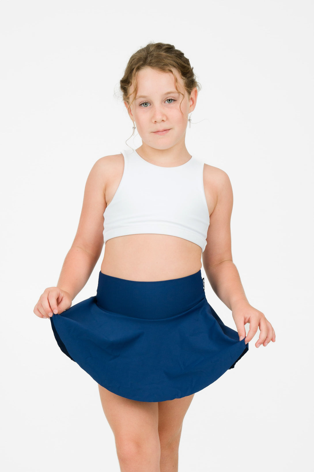 Young girl wearing exotica activewear designed for performance dancing simple skort design full coverage in a navy blue colour