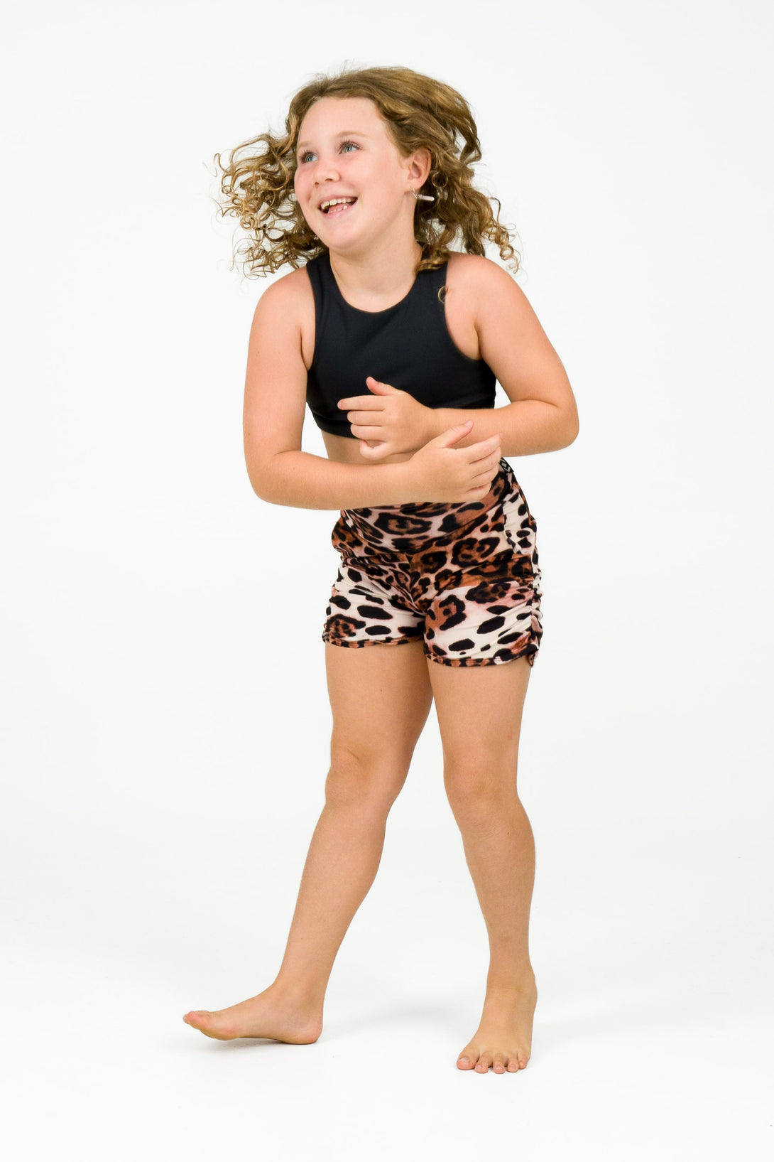 Young girl wearing activewear shorts in a leopard primal print for sports and gymnastics from exotica athletica