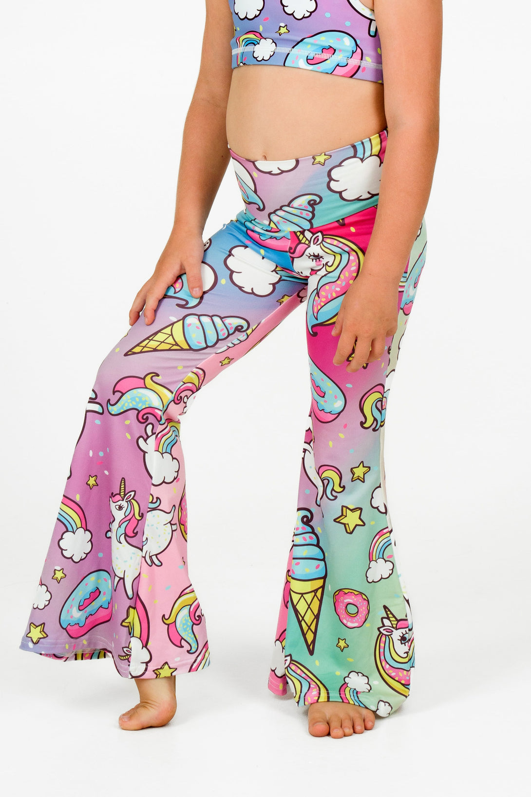 Young girl wearing activewear and loungewear from exotica athletica in a unicorn print bell leg pants